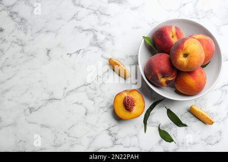 Pêches fraîches et sucrées sur une table en marbre blanc, sur une table plate. Espace pour le texte Banque D'Images