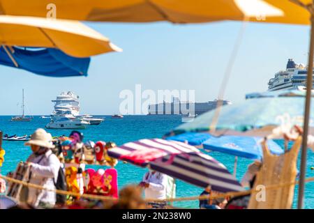 Bateaux de croisière, jet skis, voiliers, yachts et bateaux à moteur vus en mer à travers une scène colorée en bord de mer le long de la côte de Cabo San Lucas, au Mexique Banque D'Images