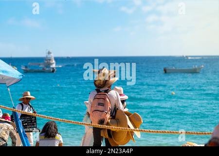 Un Mexicain vend et porte des chapeaux le long de la plage publique Playa Pública dans la ville balnéaire de Cabo San Lucas, au Mexique. Banque D'Images