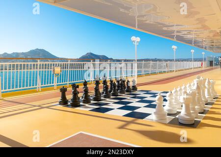 Un grand échiquier géant ou un échiquier avec des pièces d'échecs noires et blanches installé sur le pont d'un grand bateau de croisière à Cabo San Lucas, au Mexique. Banque D'Images