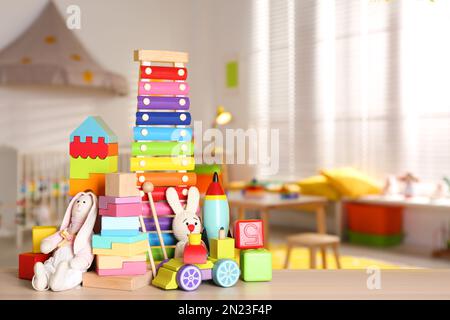 Ensemble de différents jouets lumineux sur une table en bois dans la chambre des enfants. Espace pour le texte Banque D'Images