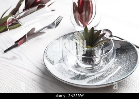 Cadre élégant avec table et décor fleuri sur fond de bois blanc Banque D'Images