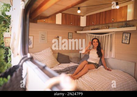 Jeune femme au lit en remorque. Vacances en camping Banque D'Images