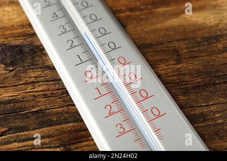 Thermomètre météo moderne sur fond en bois, gros plan Banque D'Images