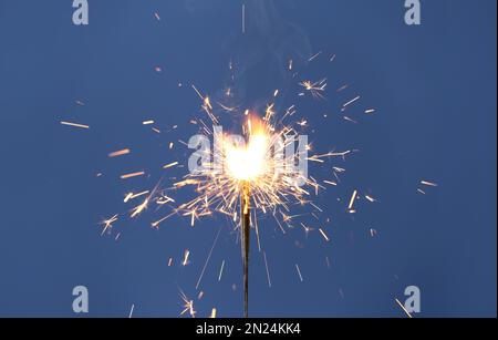 De magnifiques sparklers qui brûlent sur fond bleu. Décoration de fête Banque D'Images