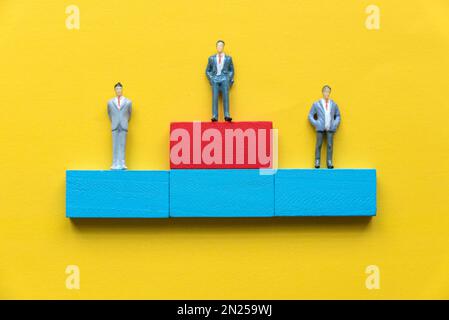 Des gens d'affaires miniatures debout sur un podium. Concept de récompense d'entreprise. Banque D'Images