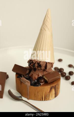 Délicieuse crème glacée au chocolat dans un cône de cachets servi sur une table blanche Banque D'Images