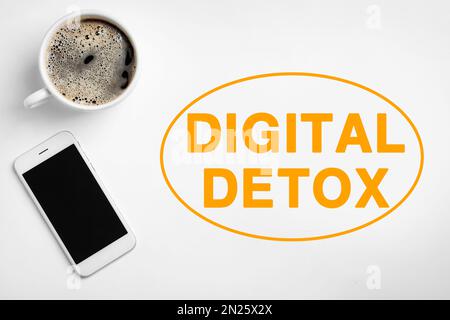 Texte Digital Detox, téléphone portable et tasse de café sur fond blanc, plat Banque D'Images