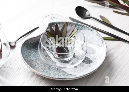 Cadre élégant avec table et décor fleuri sur fond de bois blanc Banque D'Images