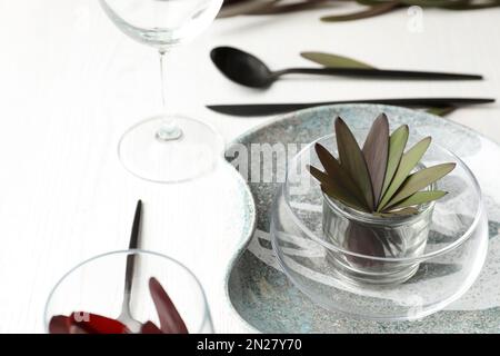 Cadre élégant avec table et décor fleuri sur fond de bois blanc Banque D'Images