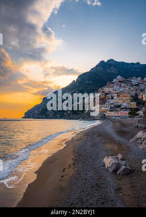 La meilleure plage de Positano, Spiaggia Grande, avec des bâtiments colorés sur les falaises qui mènent à l'océan. Côte italienne, au coucher du soleil à Positan. Banque D'Images