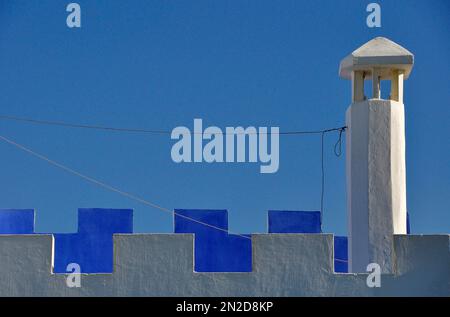 Cheminée avec des remparts blancs et bleus contre le ciel bleu, Asilah, nord du Maroc, région de Tanger-Tétouan-Al Hoceima, Maroc Banque D'Images