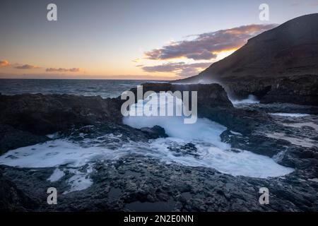 Lever du soleil à l'arche de roche Charco Manso, El Hierro, îles Canaries, Espagne Banque D'Images