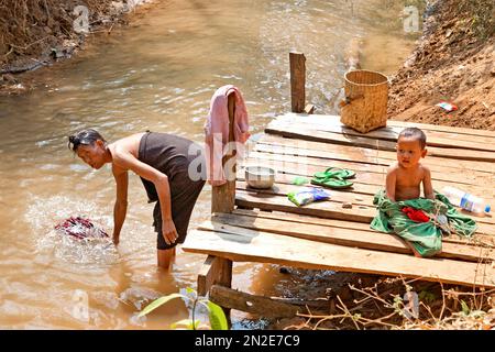 Lavage de vêtements sur les rives de la rivière Nam Pilu, excursion en bateau à Dein, Myanmar, à Dein, Myanmar Banque D'Images