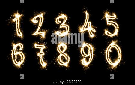 Set avec des silhouettes Numbers en sparkler sur fond noir Banque D'Images