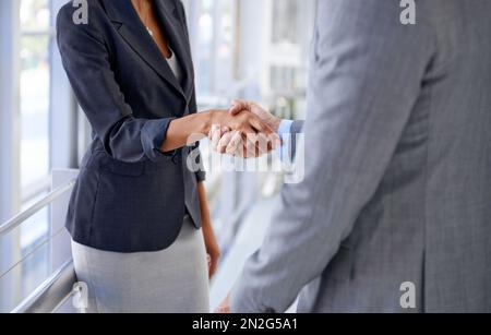 Conclure la vente. Image rognée d'un homme d'affaires et d'une femme d'affaires qui se secouent la main. Banque D'Images