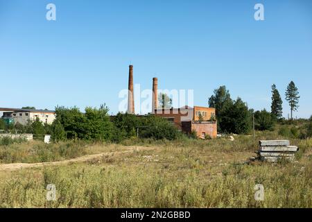 Installation de tuyauterie. Fabrique de briques à la campagne. Zone industrielle en dehors de la ville. Vieux bâtiment le jour ensoleillé. Banque D'Images