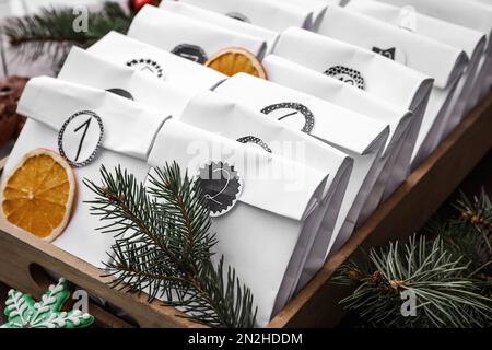 Sacs en papier en boîte en bois et décoration festive sur table, gros plan. Calendrier de l'Avent de Noël Banque D'Images