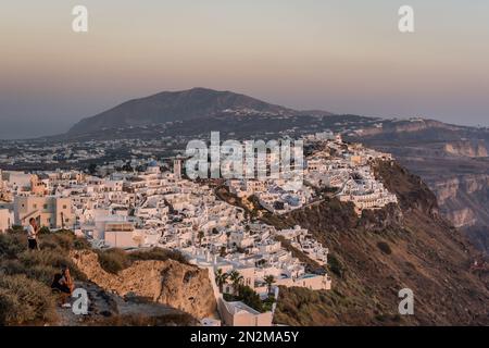 Oia, Grèce - août 2022 : vue au coucher du soleil sur la vieille ville de Fira sur l'île de Santorini Banque D'Images