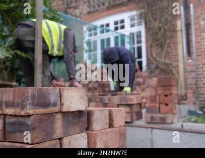 Deux ouvriers de la construction qui poncent des briques dans le cadre de la rénovation d'une maison de banlieue édouardienne dans le nord de Londres, au Royaume-Uni Banque D'Images