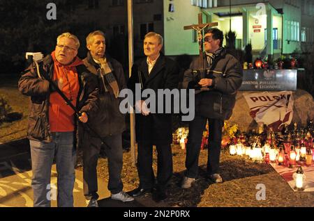 People make a recording for a local website in front of the police station in the town of Legionowo, near Warsaw, Poland, Tuesday, March 17, 2015. Rioting sparked on Sunday and Monday near the station after the death of a teenager, who apparently choked to death while trying to swallow a drug packet as narcotics officers tried to stop him, has left eight people injured and 21 detained. Disturbances were expected today, but people decide to stage a silent march next Sunday.(AP Photo/Alik Keplicz)
