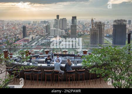 Cambodge, Phnom Penh, le Sora Sky Bar dans l'hôtel Rosewood. Quartier central des affaires avec gratte-ciel bâtiments d'affaires. Couple prenant des boissons Banque D'Images