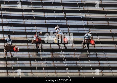 Dhaka, Bangladesh. 07th févr. 2023. Les travailleurs nettoient un mur d'une tour sur Gulshan 2 à Dhaka sans prendre de mesures de sécurité. Crédit : SOPA Images Limited/Alamy Live News Banque D'Images