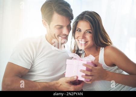 Couple, cadeau ou cadeau pour la fête du portrait de jour de Saint Valentin avec amour, soin et surprise dans la chambre. Homme et femme dans la maison heureuse avec boîte pour Banque D'Images