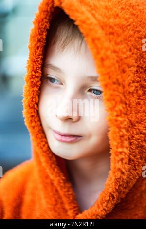 Portrait en gros plan d'un garçon portant un sweat à capuche orange Banque D'Images
