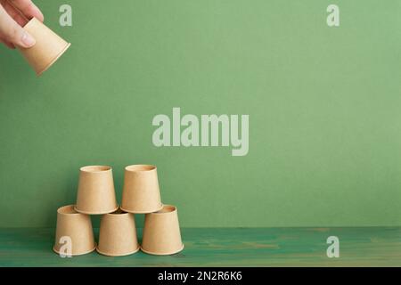Pile pyramidale de tasse brune sur table en bois. arrière-plan vert. développement de l'entreprise concept de croissance de la réalisation Banque D'Images