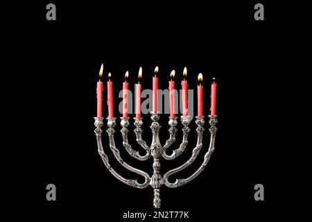 Menorah argentée avec bougies allumées sur fond noir. Célébration Hanukkah Banque D'Images