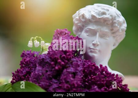 27 mai 2021 Biélorussie, ville de Gomel, studio de photo.les branches de Lilac se trouvent à la tête de Michel-Ange. Le concept de créativité et d'art. Banque D'Images