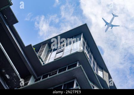 Un avion survole des bâtiments modernes de la ville Banque D'Images