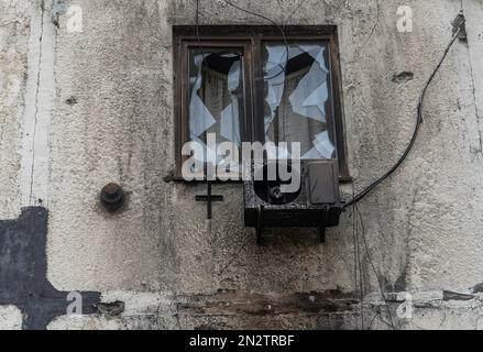 Fenêtre avec un climatiseur brûlé dans un immeuble d'appartements (gros plan). La guerre en Ukraine. Invasion russe de l'Ukraine.crimes de guerre Banque D'Images