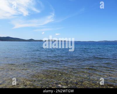 Plage sauvage de pierre de Sukosan à côté de Jadranska Magistrala jour eau cristalline Banque D'Images