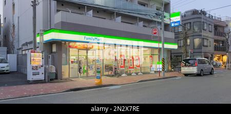 La vitrine de la boutique a tourné un FamilyMart, un magasin de proximité japonais populaire au crépuscule après avoir allumé les lumières du magasin. Banque D'Images