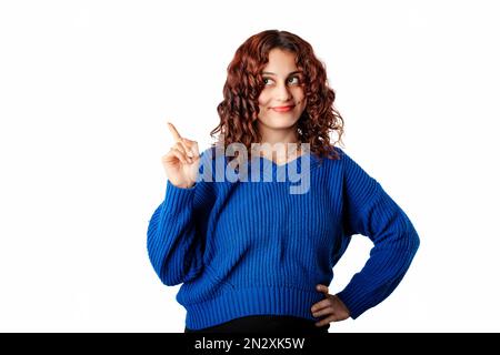 Portrait de la jeune femme portant le pull bleu pull isolé sur fond blanc secouant l'index et grimaquant hésitant, ont suggestion ou W Banque D'Images