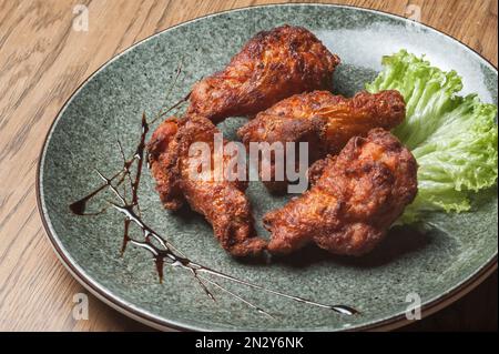 Plats du chef du restaurant. Un plat sur une table dans un café. Plats appétissants du menu du restaurant. Plats frais et savoureux. Cuisse de poulet frite Banque D'Images