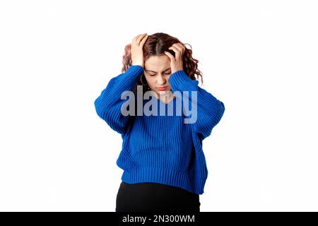 Portrait d'une femme mignonne debout isolée sur fond blanc tenant la tête avec les mains souffre d'un mal de tête grave. Semble très en colère et malade. A St Banque D'Images