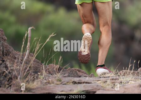 Piste d'athlète en montagne sur terrain rocailleux, détail chaussures de sport Banque D'Images