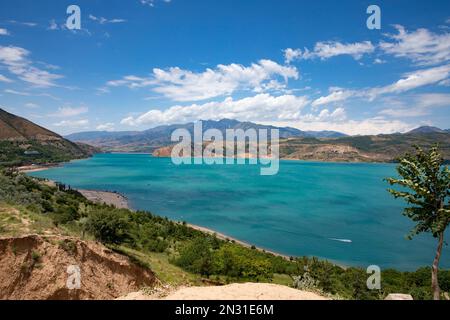 Vue panoramique sur le réservoir de Charvak sous un ciel bleu et nuageux en Ouzbékistan Banque D'Images