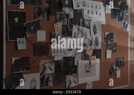 Tableau de détection avec photos de scènes de crime, empreintes digitales, indices et fil rouge sur le mur Banque D'Images