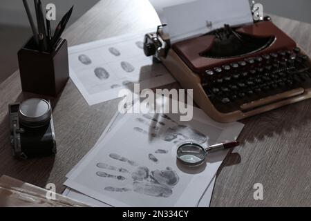 Machine à écrire, empreintes digitales et papiers sur le bureau. Le lieu de travail du détective Banque D'Images