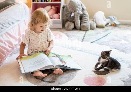 Roanoke, Virginie USA - août 24 2021 : enfant lisant un livre avec le chaton Banque D'Images