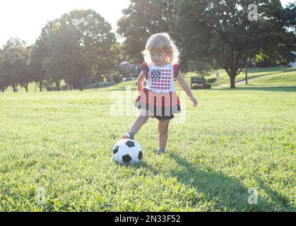 petit enfant jouant au football. Blanc caucasien petite fille joue au football. Banque D'Images