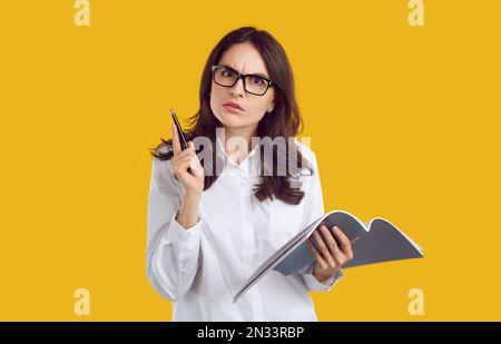Portrait d'une femme d'affaires avec un stylo et un organisateur vient avec des idées et des projets de travail. Banque D'Images