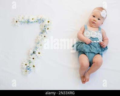 Petite fille de nouveau-né caucasienne dans une robe bleue. bébé de 7 mois Banque D'Images