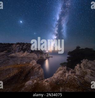 Milky Way et phare sur le sommet de la montagne à la nuit étoilée Banque D'Images