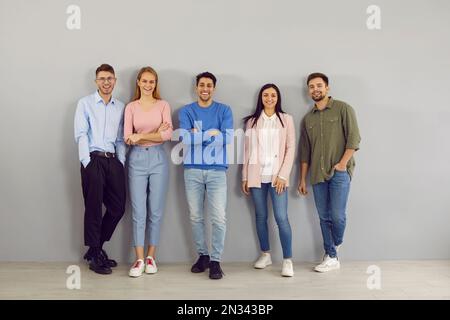Portrait d'un groupe de jeunes intelligents positifs différents sur fond de mur gris. Banque D'Images