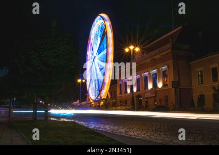 Photo en exposition longue d'une grande roue en mouvement illuminée la nuit, Balassagyarrat, Hongrie Banque D'Images